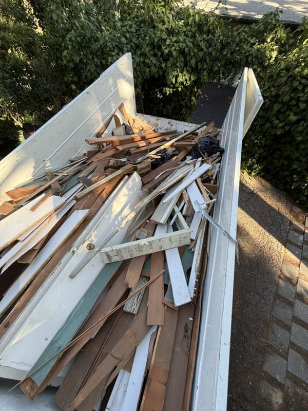 Pile of lumber, painted trim and timber offcuts stacked against a wall after a Largo remodel