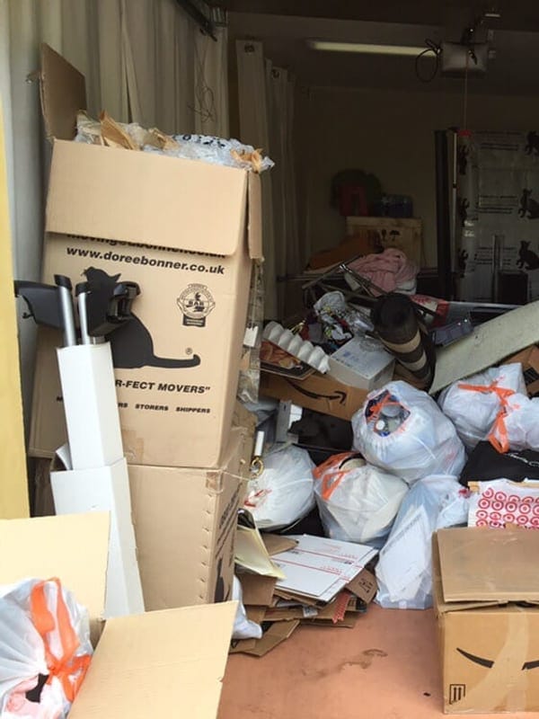 Garage packed to the door with moving boxes, bagged clothing and shelving in Largo, FL