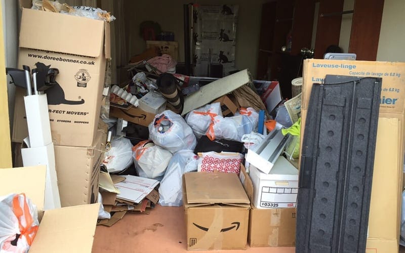Moving boxes, bagged clothing and shelving packed front to back in a Largo garage