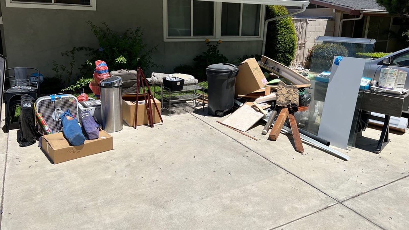 Household junk, cardboard and old furniture piled on a driveway outside a Largo, FL home ready for removal