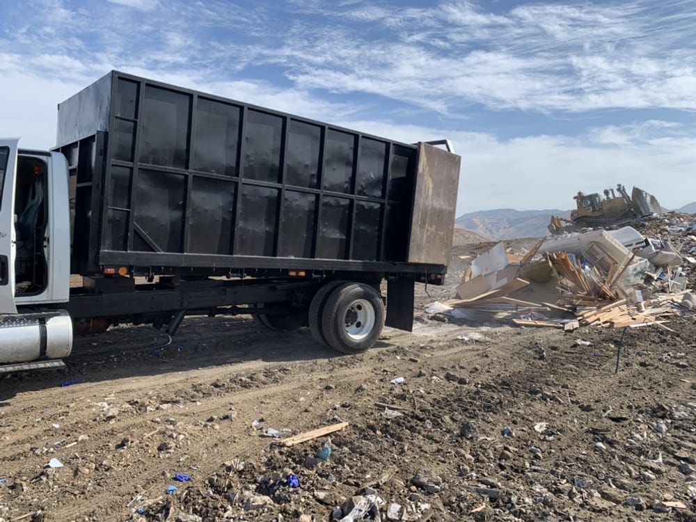 Large open-body hauling truck on site for a retail and warehouse clearance