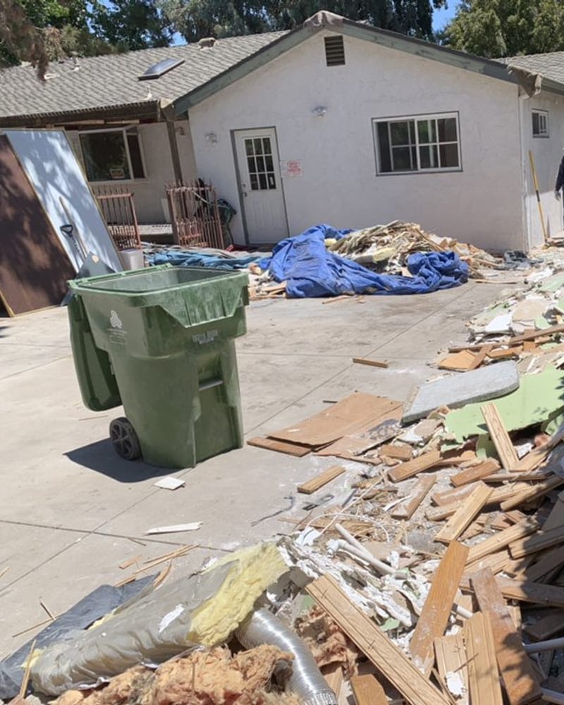 Lumber, drywall and flooring debris piled outside a single-story home mid-renovation in Largo, FL
